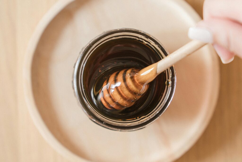 Top view of honey dipper in a jar, perfect for culinary and food themes.